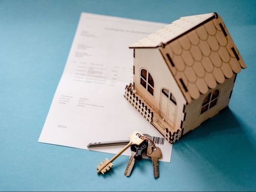 Image of model house and contract to represent a rental agreement